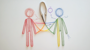 Dessins de bonhommes allumettes sur fond blanc. Des couleurs liées aux chakras relient les deux dessins. Une paire de ciseaux coupe la relation au milieu.